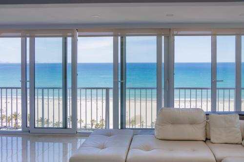 a living room with a white couch in front of the ocean at Texas in Alicante