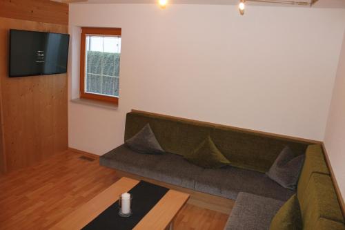 a living room with a couch and a tv at Chalet Mühle in Längenfeld