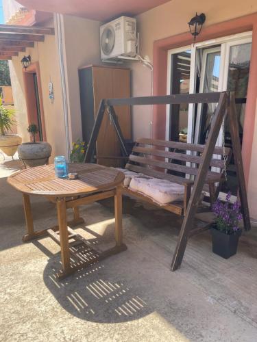 a wooden bench and a table in a room at Medusa Apartment in Artemida