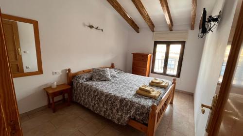 a bedroom with a bed with two towels on it at CA LIDIA -Allotjament Rural EL BALCONET in Benimantell