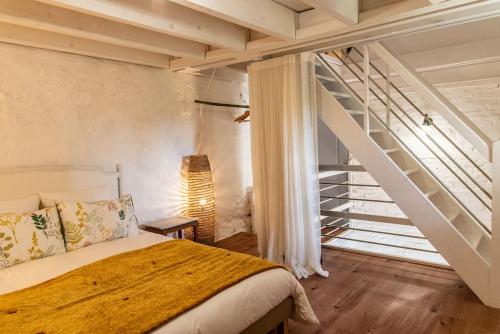 a bedroom with a bed and a stair case at Gîte Bleu - Les Gîtes de La Closerie - Charme & Détente en Sud Touraine - Châteaux de la Loire in Le Tranger