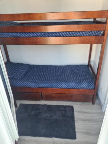 une couchette inférieure d'un lit superposé avec un matelas bleu dans l'établissement Appartement Duplex 3 chambres, à Pornichet