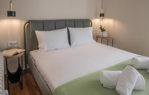 a bedroom with a large bed with white sheets at Wonder Apartment over the Sea in Athens