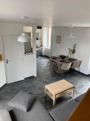 un salon avec une table et une salle à manger dans l'établissement Le Dauphiné, à Mortagne-sur-Sèvre