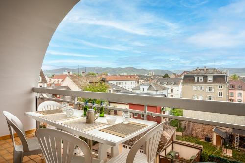 een tafel en stoelen op een balkon met uitzicht bij L' Appart BELLE VUE GARE ET CENTRE 10 mn à pied GARAGE GRATUIT in Colmar