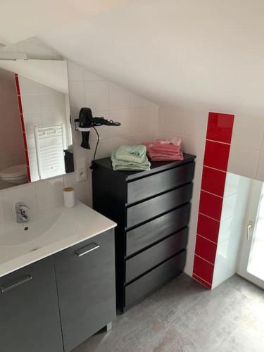 La salle de bains est pourvue d'un lavabo et d'un comptoir avec un miroir. dans l'établissement Le Dauphiné, à Mortagne-sur-Sèvre