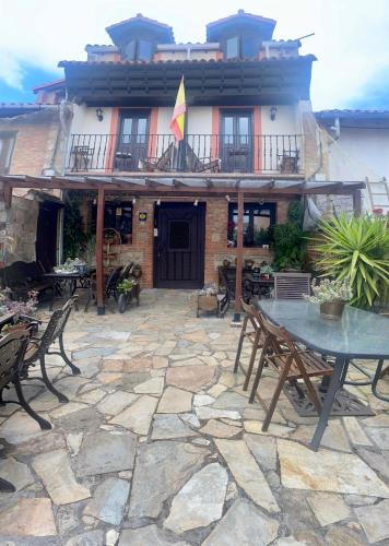 a patio with a table and chairs in front of a building at Alojamiento Rural Monterey in La Revilla