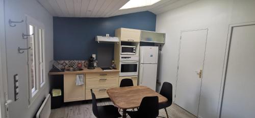 une petite cuisine avec une table et un réfrigérateur dans l'établissement Chez Sophie et Anne Lise, à Bourcefranc