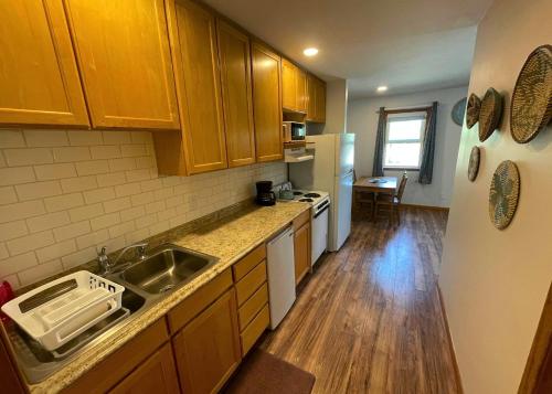 a kitchen with wooden cabinets and a sink and refrigerator at The Edenwild Boutique Inn in Lopez