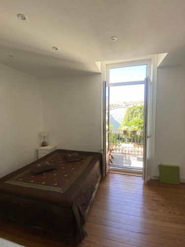 - une chambre avec un grand lit et une porte coulissante en verre dans l'établissement Meublés d'Anna, à Aix-les-Bains