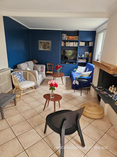 d'un salon orné de meubles et d'un mur bleu. dans l'établissement Les Pâquerettes, gîte de campagne 1300 m2 de terrain à 20min du Puy du Fou, à Montravers