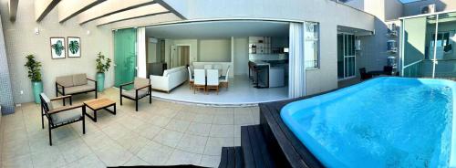 a large blue swimming pool in a house at Linda Cobertura duplex- 306 Bayside in Bombinhas