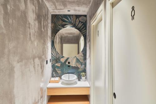 - un couloir avec une salle de bains pourvue d'un lavabo et d'un miroir dans l'établissement Hostal Sol y Miel, à Benalmádena