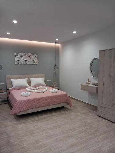 a bedroom with a large bed with a pink blanket at Kolymbia summer holidays in Kolymbia