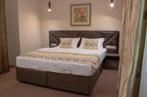 a bedroom with a large bed with pillows at Silk Way in Almaty