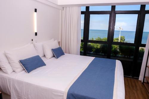 a bedroom with a bed with a view of the ocean at Marante Plaza Hotel in Recife