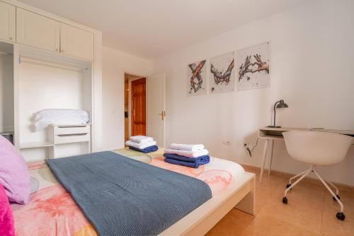 a bedroom with a bed with a sink and a desk at Casa Emma in Corralejo