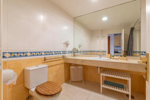 a bathroom with a toilet and a sink and a mirror at Casa Emma in Corralejo