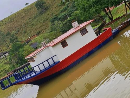 a large boat is sitting in the water at Chalé Barco Recanto Buscapé SFX in São Francisco Xavier
