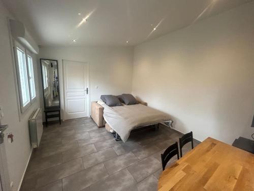 a bedroom with a bed and a table in it at maison proche du Groupama Stadium in Décines-Charpieu