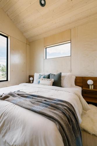 a large bed in a room with two windows at Yellowstone Peaks Hotel in Island Park