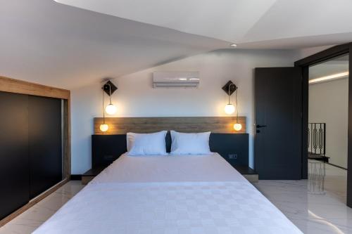 a bedroom with a large white bed with two pillows at Minta Hills Villas Kemer in Antalya