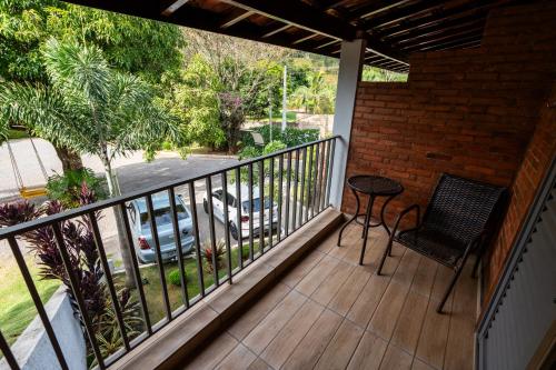 a balcony with a table and a chair on a porch at Vale das Orquídeas Pousada in Socorro
