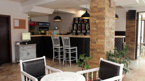 a bar with chairs and a counter in a room at Хотел Хилез Hotel Hilez in Tryavna