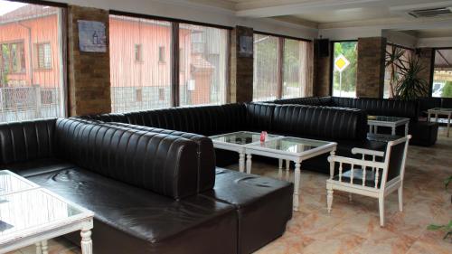a restaurant with black leather couches and a table at Хотел Хилез Hotel Hilez in Tryavna