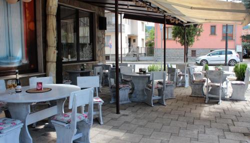 a patio with tables and chairs in front of a building at Хотел Хилез Hotel Hilez in Tryavna