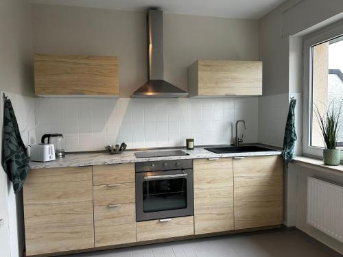 una cucina con mobili in legno e un forno a piano cottura di Ferienwohnung Mia a Niestetal