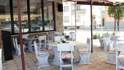 a table and chairs in front of a restaurant at Хотел Хилез Hotel Hilez in Tryavna
