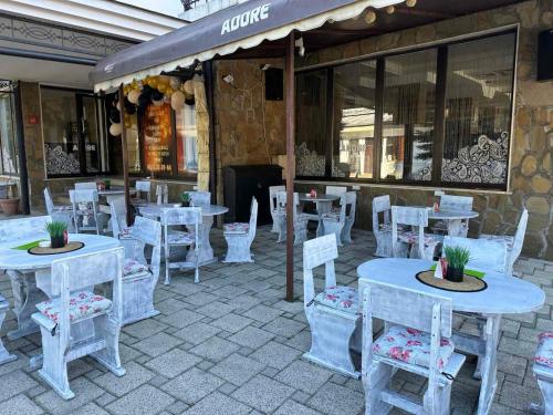 un restaurant avec des tables blanches et des chaises blanches dans l'établissement Хотел Хилез Hotel Hilez, à Tryavna