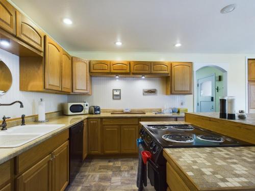 a kitchen with wooden cabinets and a stove top oven at Daffodil Cottage in Downtown Packwood, WIFI, BBQ, Firepit, Smores in Packwood