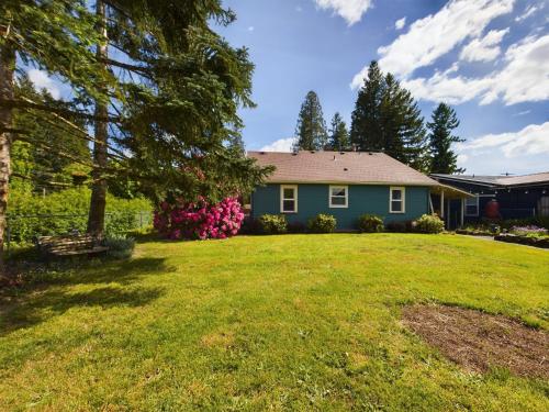 a house with a yard with a green lawn at Daffodil Cottage in Downtown Packwood, WIFI, BBQ, Firepit, Smores in Packwood