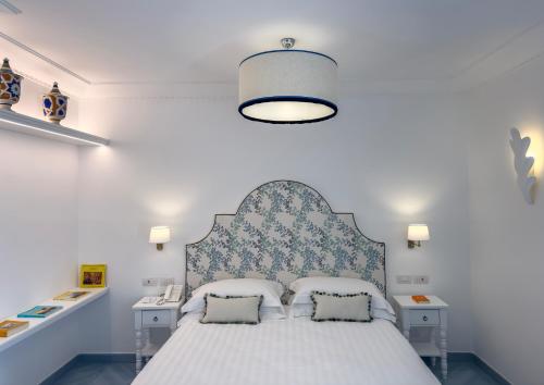 a bedroom with a bed with a blue and white headboard at Boutique Hotel Casa Mariantonia in Anacapri