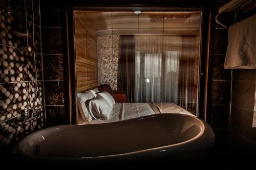 a bath tub in a room with a bed at My Green Boutique Hotel in Masukiye