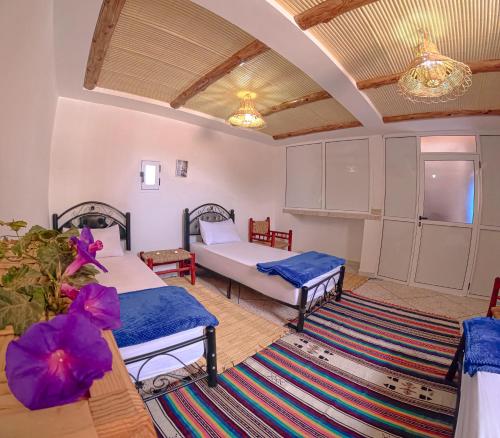 a living room with two beds and a table at Riptide Surf House in Taghazout