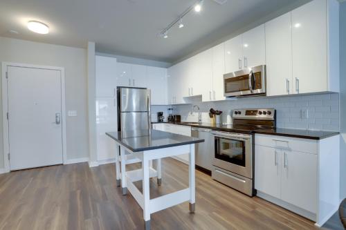 a kitchen with white cabinets and a black counter top at Modern & Bright Apartment in Alexandria in Alexandria