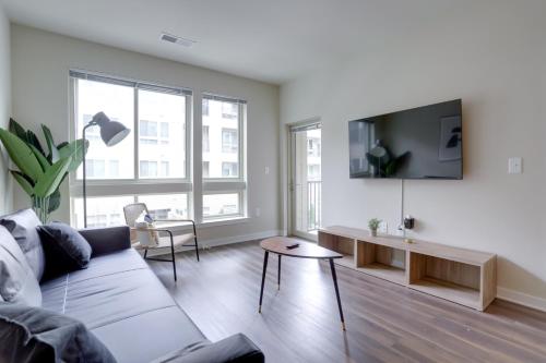 a living room with a couch and a tv on a wall at Modern & Bright Apartment in Alexandria in Alexandria