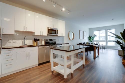 a kitchen and dining room with white cabinets and a table at Modern & Bright Apartment in Alexandria in Alexandria