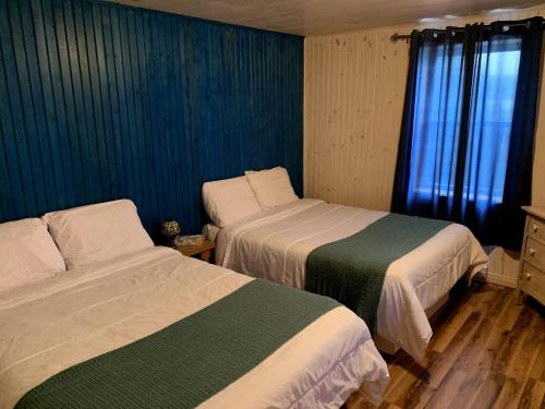two beds in a room with blue walls at Centre de Vacances 5 Étoiles Family Resort in Sacré-Coeur-Saguenay