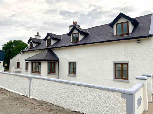 a white house with a black roof at The Stables Farmhouse in New Ross