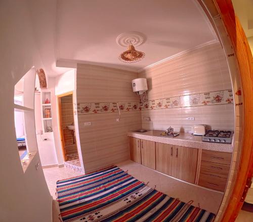 a kitchen with a large circular mirror in a room at Riptide Surf House in Taghazout