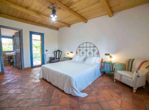 a bedroom with a white bed and two chairs at Domus Nirale in Bagnoregio
