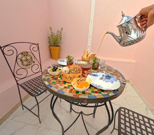 a table with a plate of food and a kettle at Riptide Surf House in Taghazout