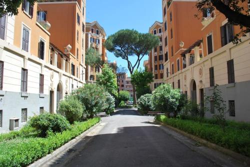 an empty street between buildings with a tree in the middle at Domus 95 in Rome
