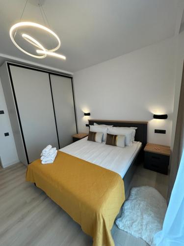a bedroom with a large bed with a yellow blanket at BinderHaus 27 in Sibiu