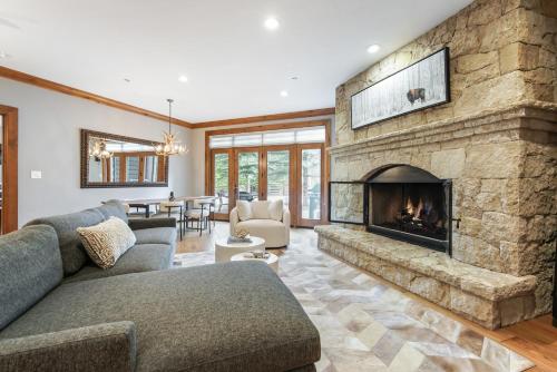 salon z dużym kamiennym kominkiem w obiekcie Ski-in Ski-out 1 BRDen in exclusive Horizon Pass condo w mieście Avon