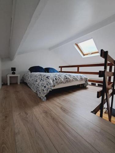 - une chambre avec un lit sur du parquet dans l'établissement Maison au calme, proche de Paris, à LʼHay-les-Roses